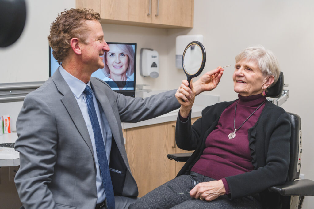 Dr. Murphy evaluating eyelids of female patient during Ptosis surgery consultation in office