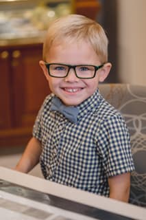 Young boy wearing glasses and bow tie